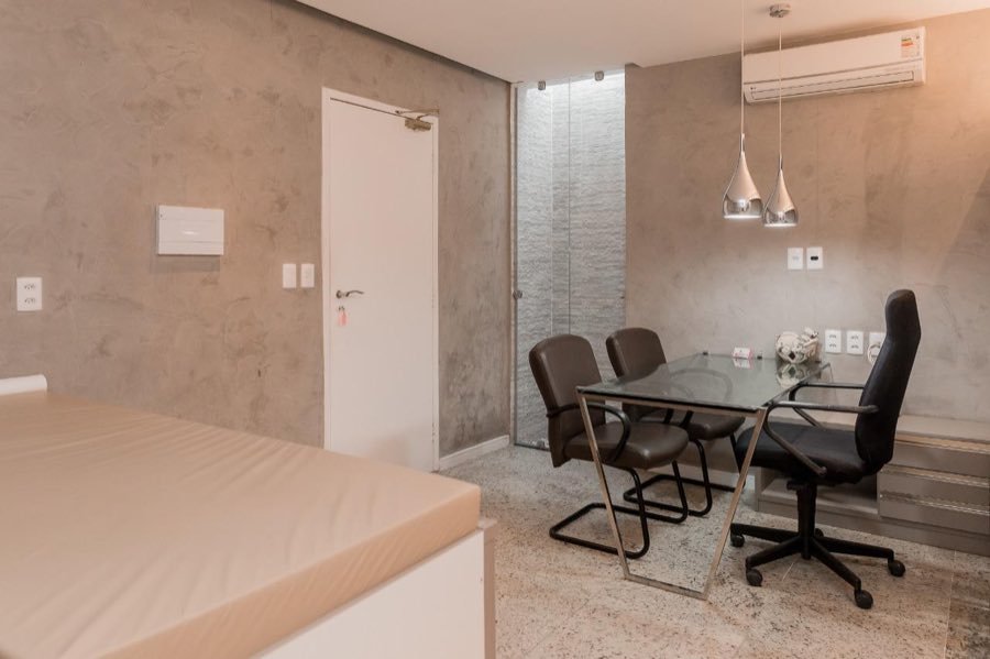 Consultório com mesa de reunião e jardim de pedras ao fundo